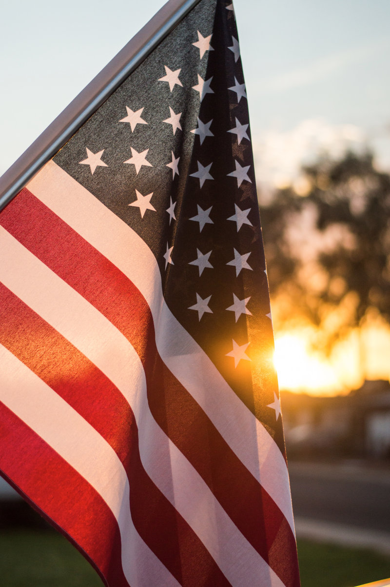 American Flag with sun on horizon